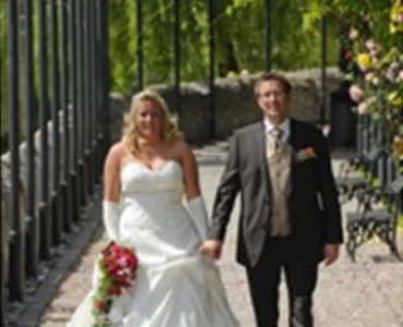 Happy bride and groom walking hand in hand in garden