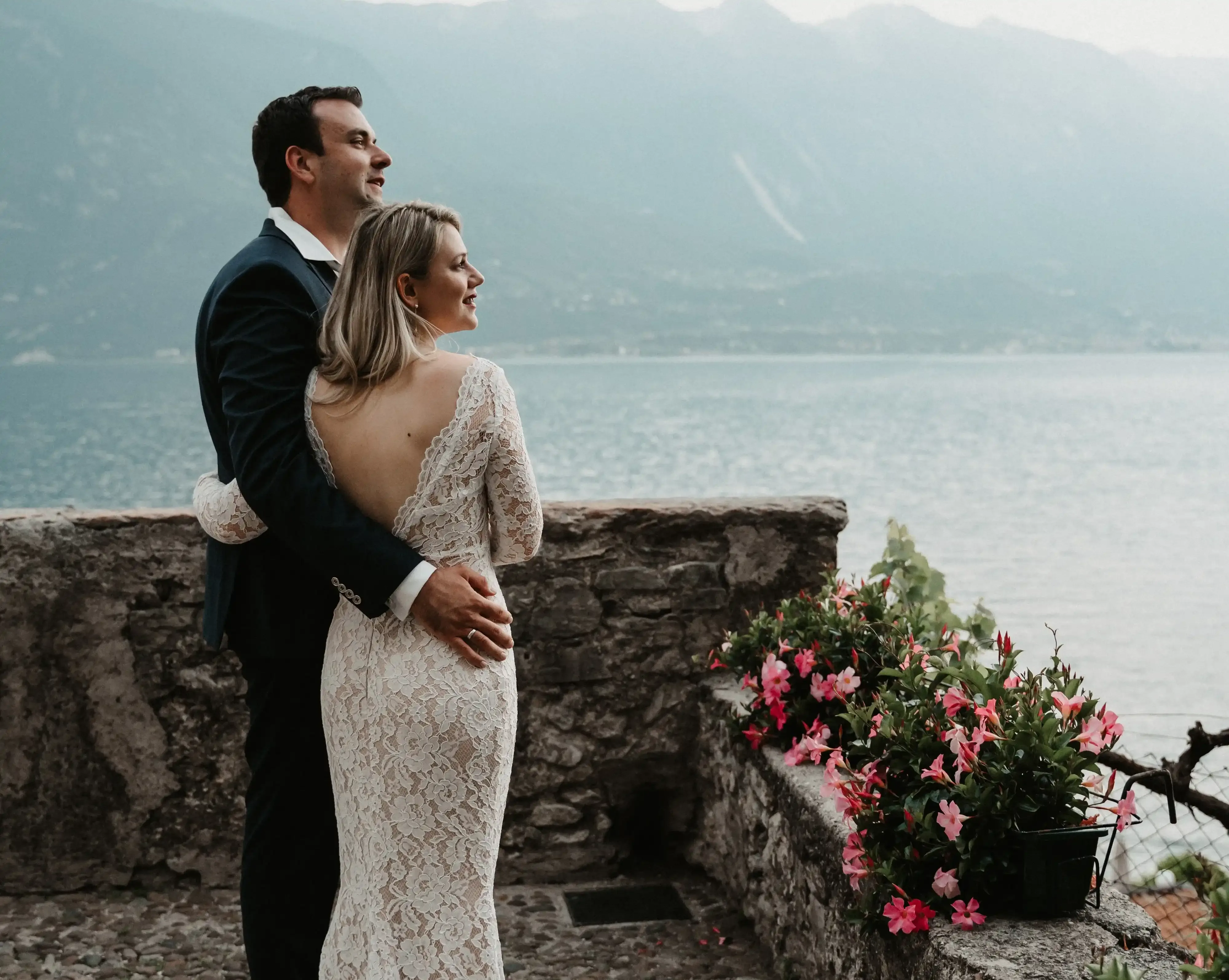 Couple de mariés enlacés avec vue sur le lac et les montagnes