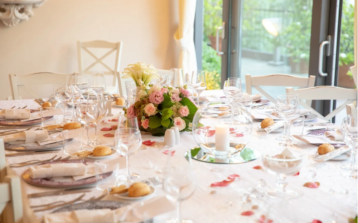 Elegant dining table with floral centerpiece and rose petals