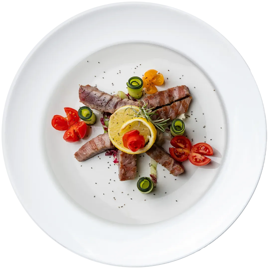 Gourmet plate of grilled meat with zucchini, cherry tomatoes and lemon slice