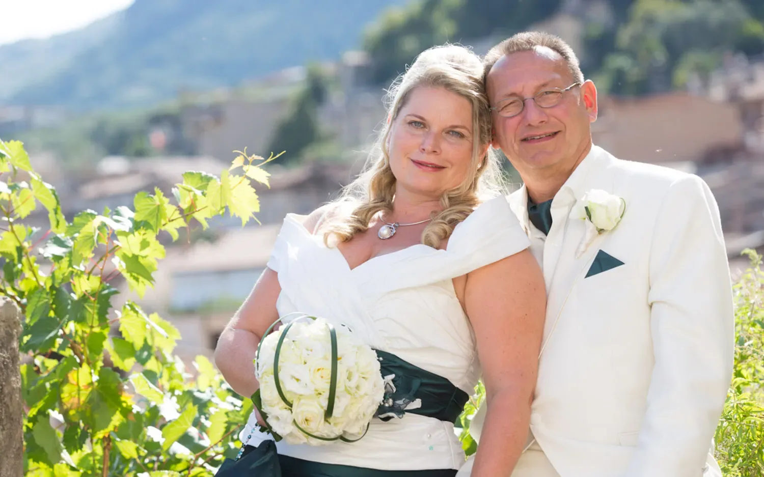 Happy bride and groom posing outdoors on wedding day