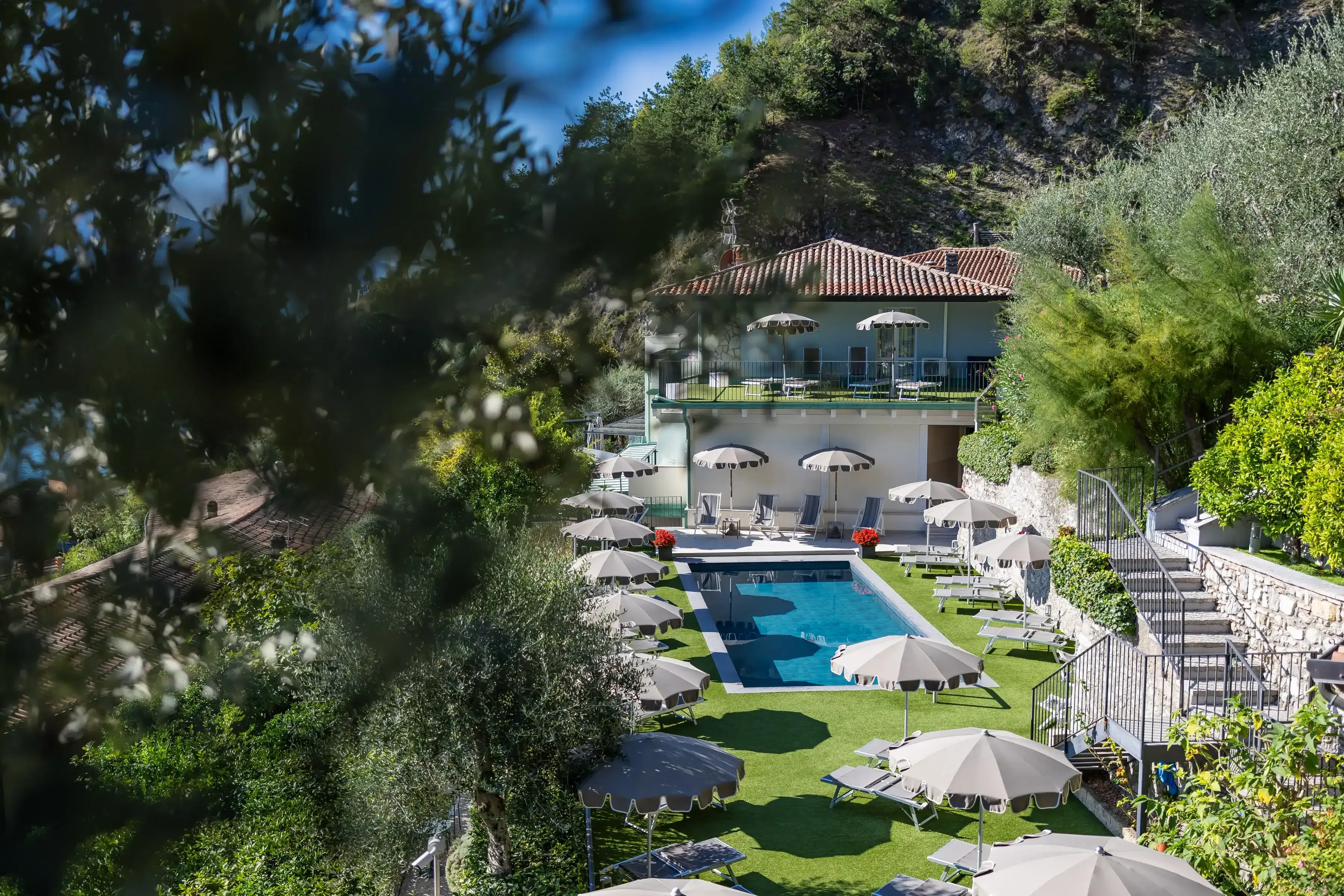 Hotel z basenem i leżakami wśród zieleni na zboczu wzgórza