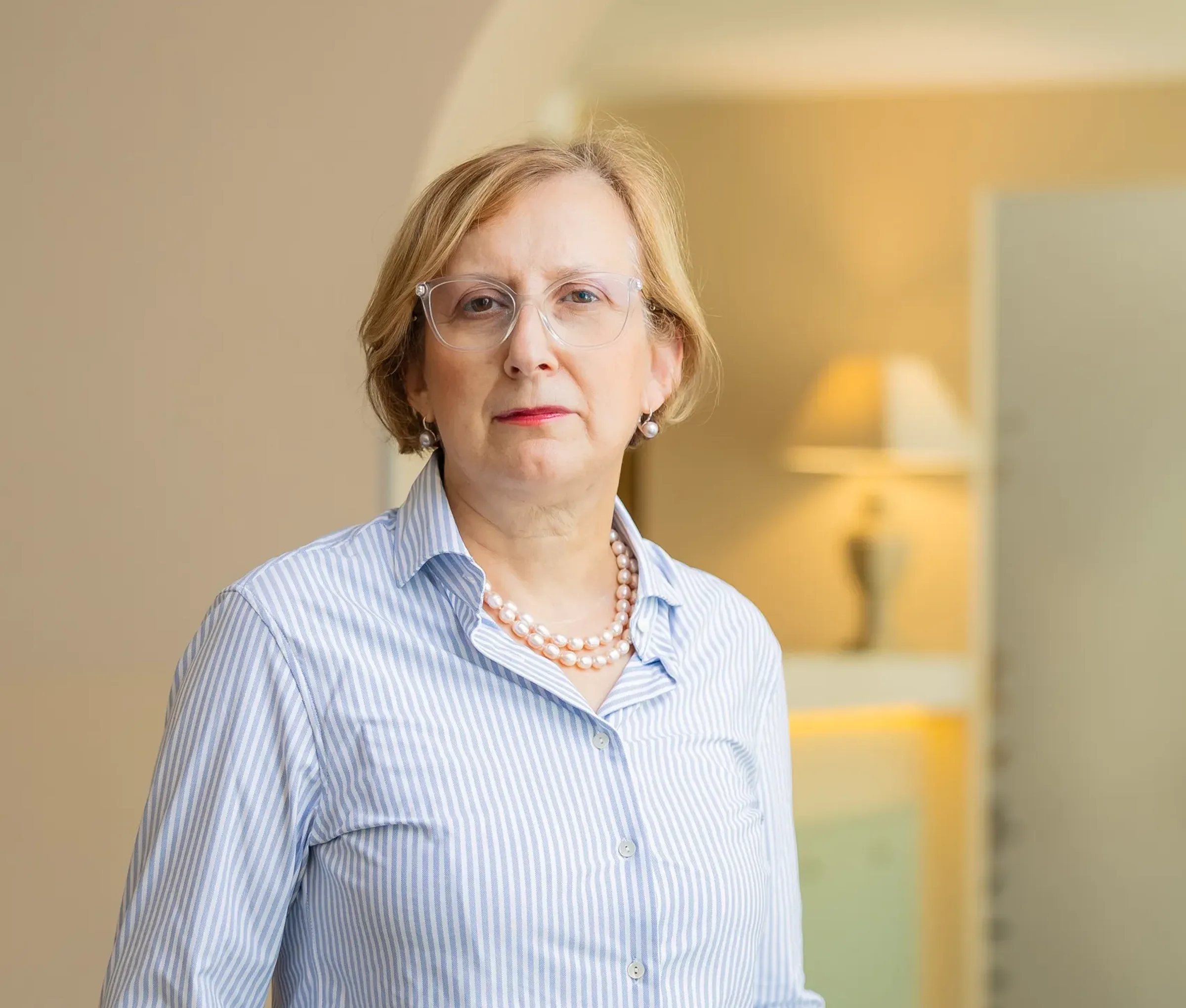 Mature woman wearing striped shirt and pearl necklace