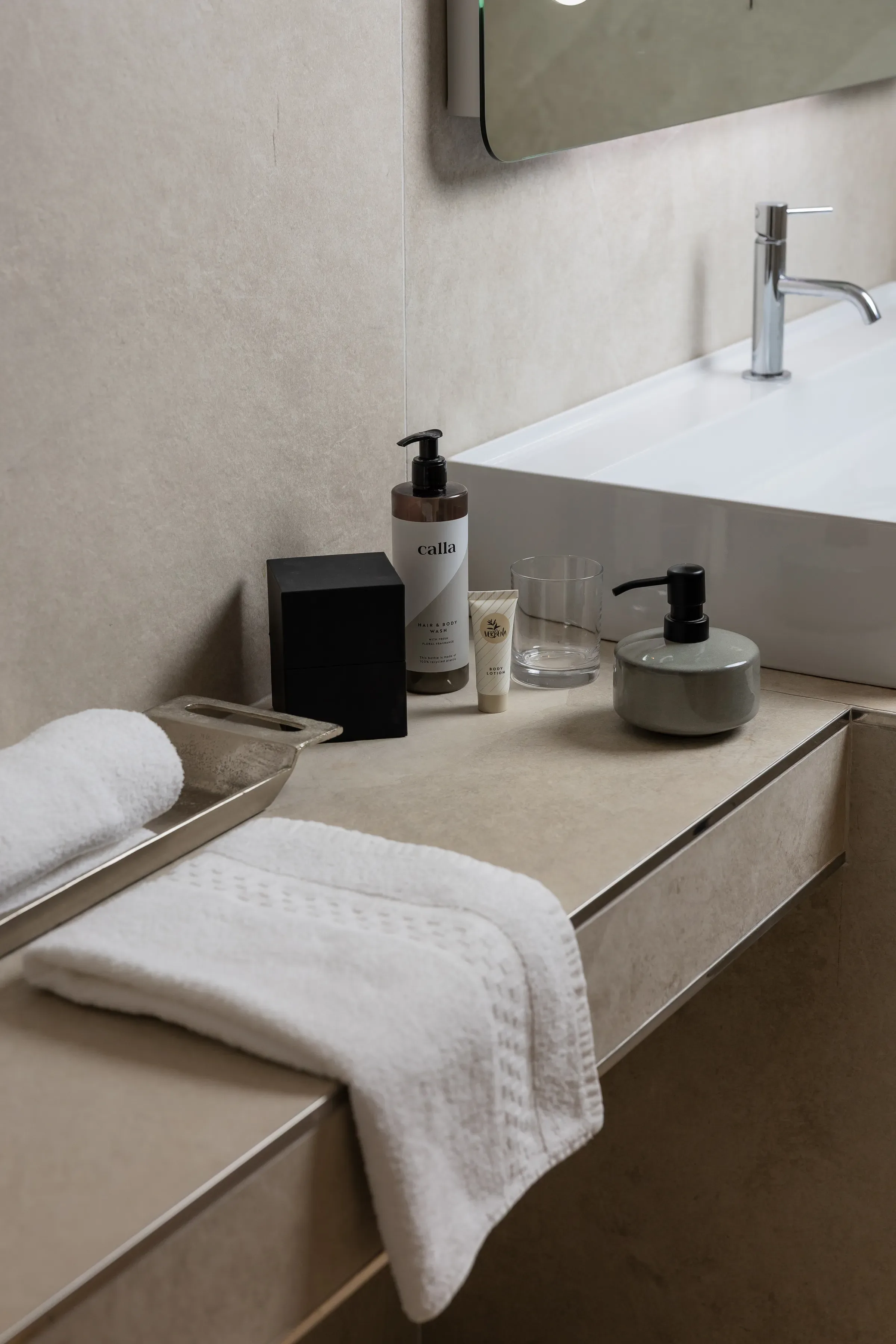 Salle de bain moderne avec serviettes et produits de toilette sur le lavabo