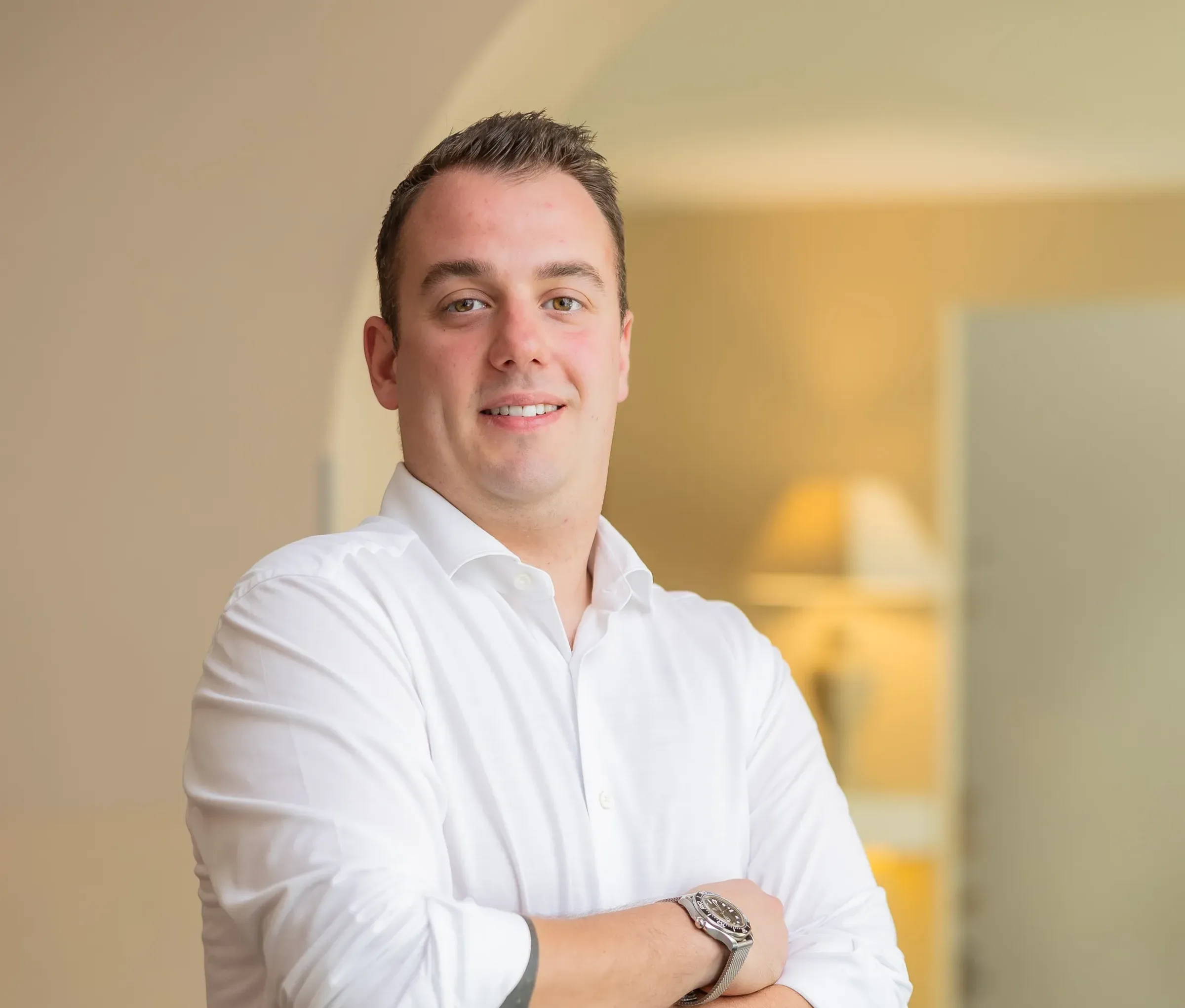 Smiling man in a white shirt with arms crossed