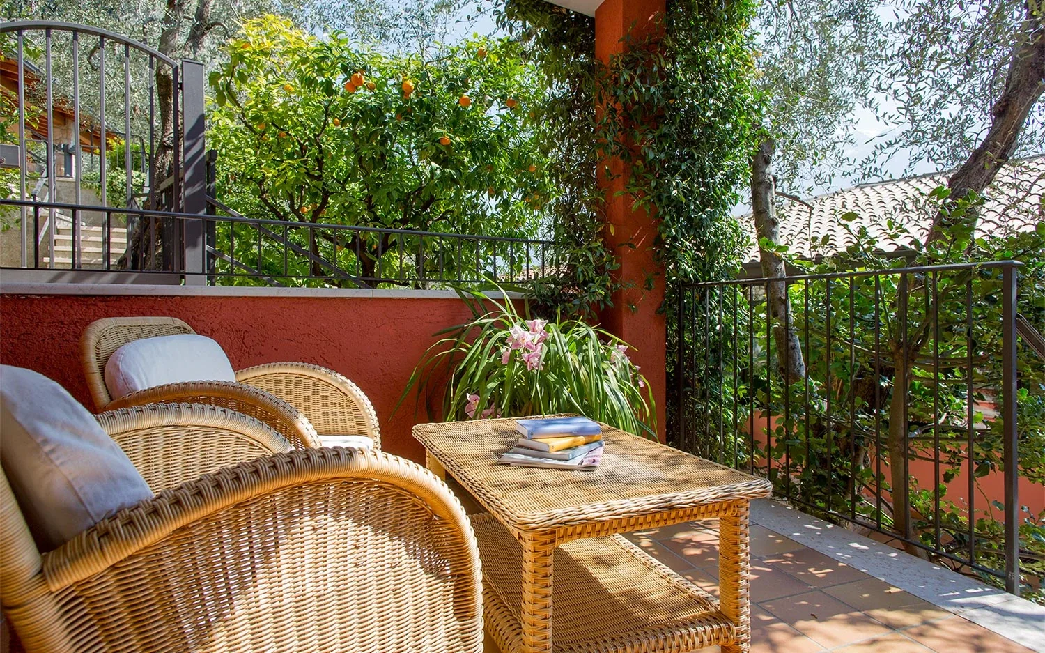 Terrasse ensoleillée avec fauteuils en osier et plantes vertes