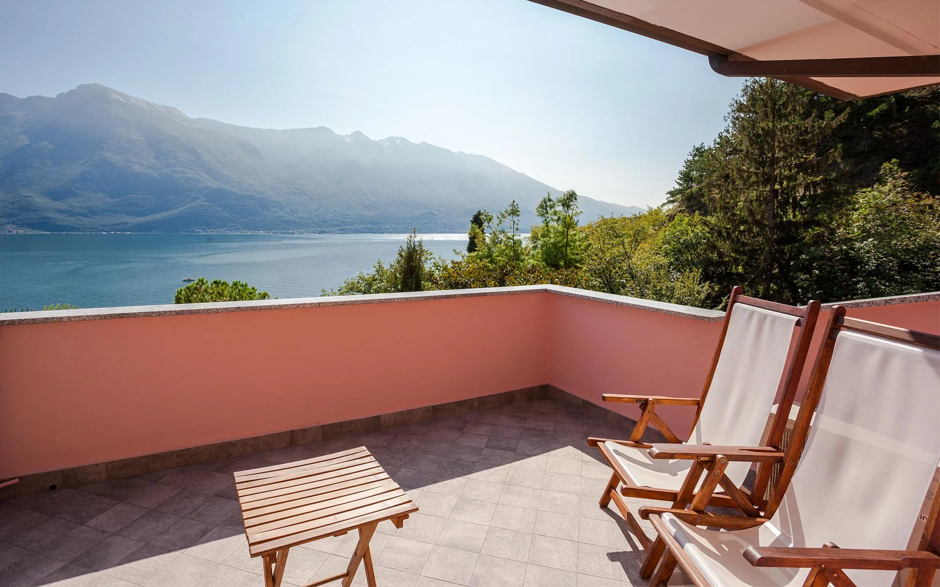 Terrasse avec chaises longues et vue sur le lac et les montagnes