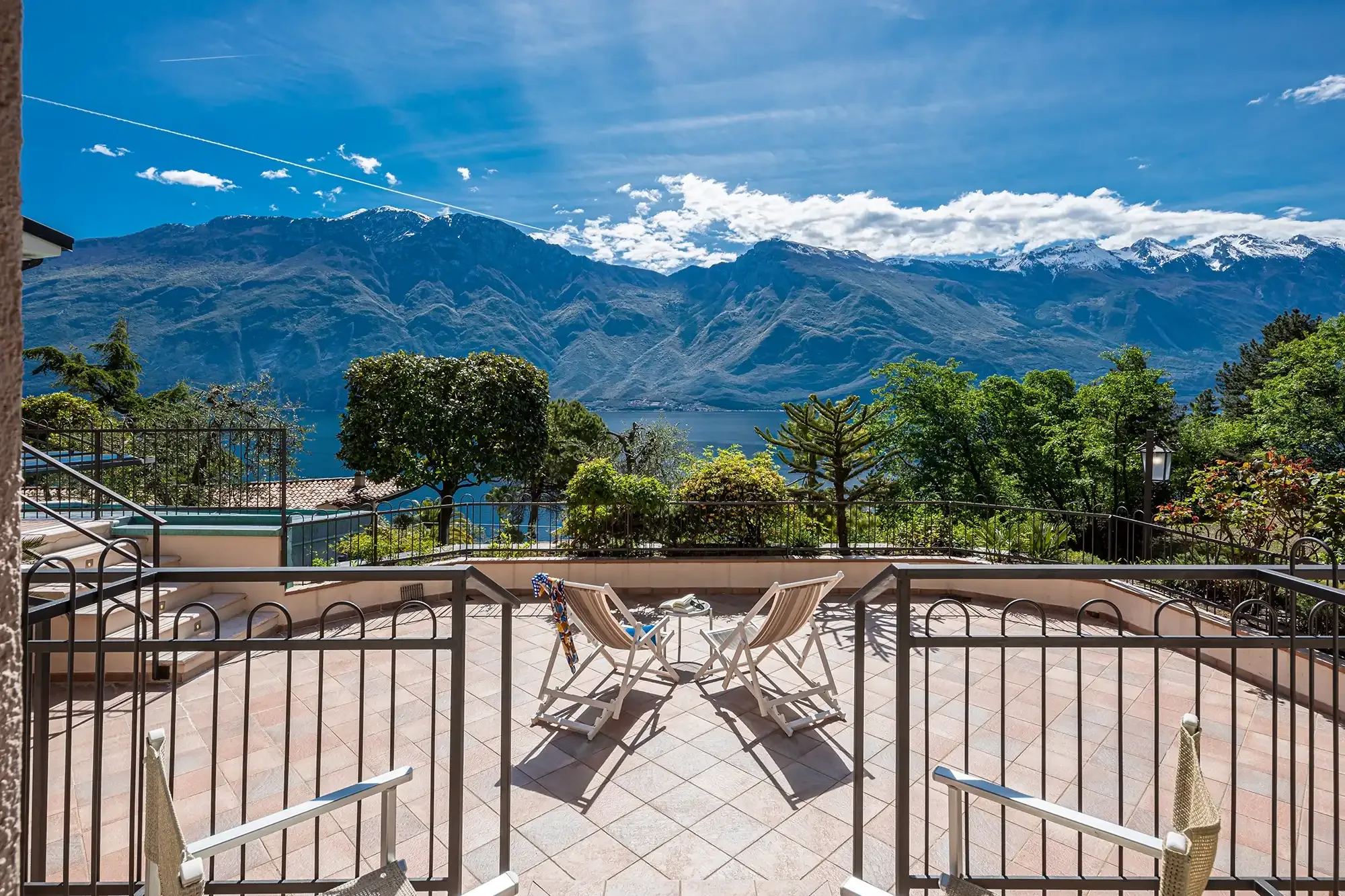 Terrasse avec chaises longues et vue sur le lac et les montagnes