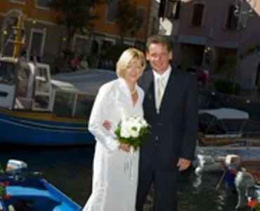Wedding couple standing by a harbor with boats