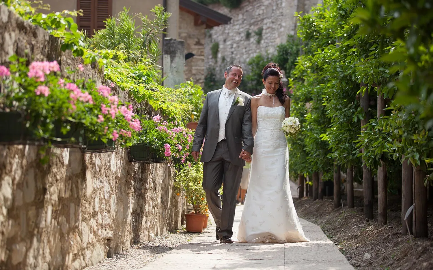 Happy wedding couple walking through a flowered garden