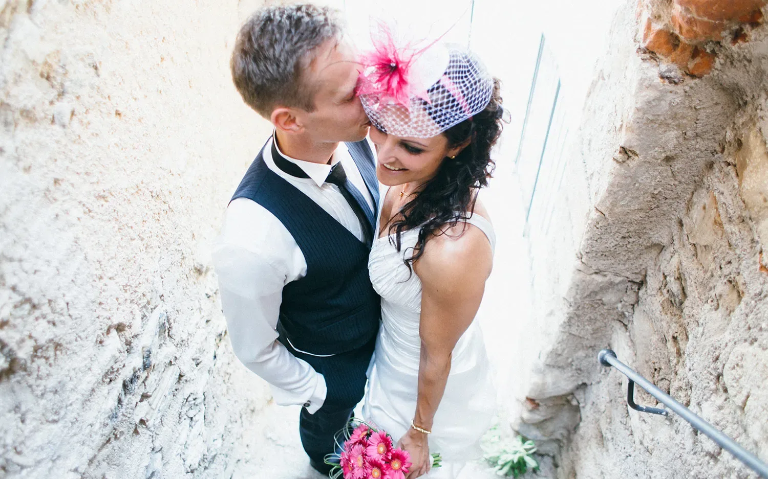 Happy newlyweds embrace on a rustic stone staircase